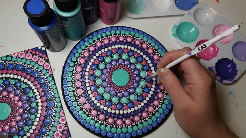 Artist painting a dot mandala