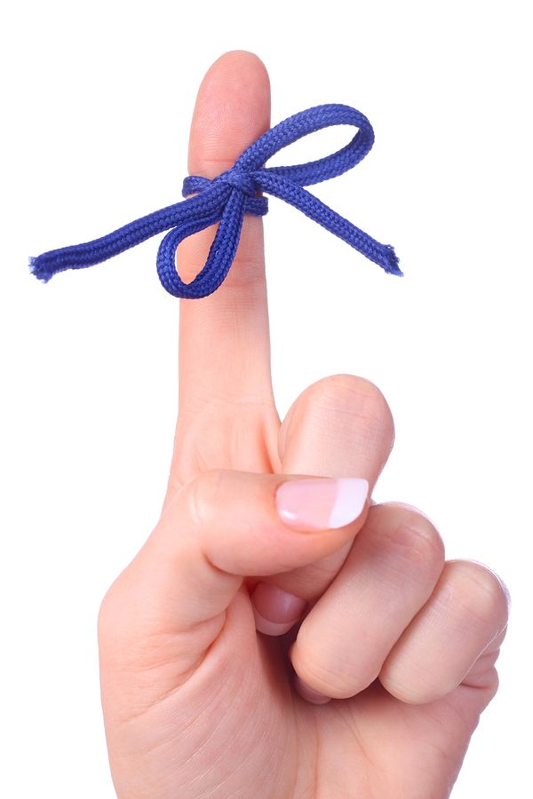 A finger contains a bow-tied string as a reminder to perform a specific task