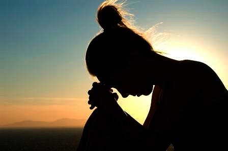 Silhouette of a woman with head bowed
