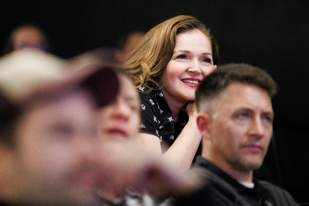 Student watching an UP Improv show, smiling