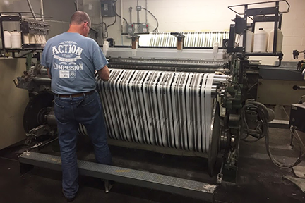 Marty Ellis, of Inman Mills in South Carolina, checks a machine manufacturing fabric developed through AFFOA. Credits Courtesy of the AFFOA