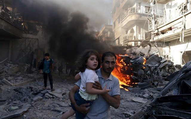 A man carries a girl as they rush away from a site hit by airstrikes from forces loyal to Syria's President Bashar al-Assad in the Douma neighborhood of Damascus, Syria, on August 24, 2015.